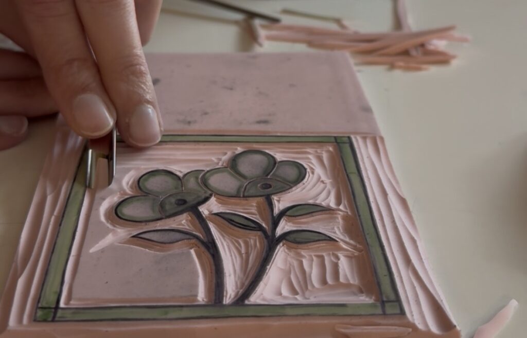The image is decorative and shows the artist carving one of her prints, the one called "Dew." At this time in the process, the print included a thin frame around the edges. This was later removed on the final version of the print.